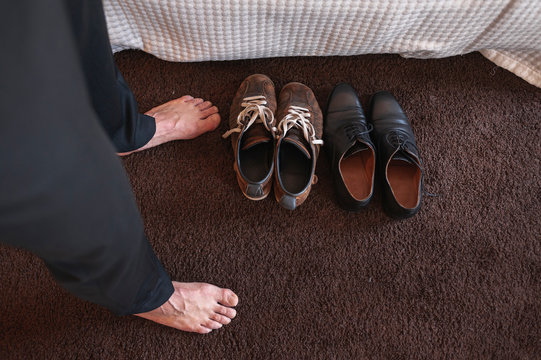 Close up of groom chosing shoes for a wedding bare feet