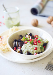 Roasted aubergines with pesto sauce decorated with pomegranate seeds.