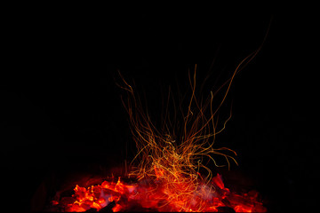 Fototapeta na wymiar Close up photography of warm charcoal making sparks