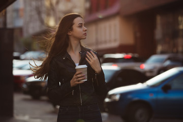 Woman enjoying to walking with coffee cup in city street
