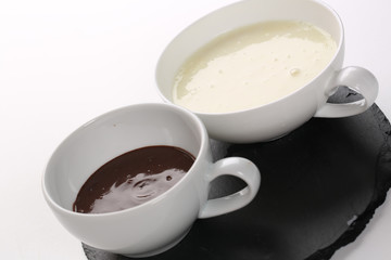 close up of cup of white hot chocolate on a white