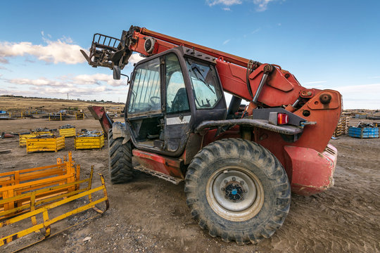Forklift on a construction site, preparing to raise construction parts