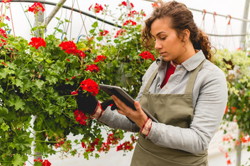 Young florist holding digital tablet