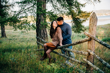 Naklejka na ściany i meble photo shoot of a beautiful brunette and her boyfriend in nature