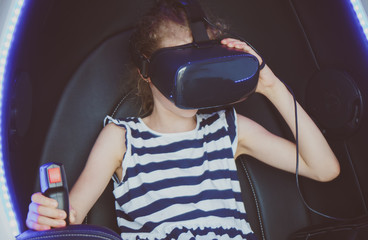 Little girl in helmet playing virtual reality game.