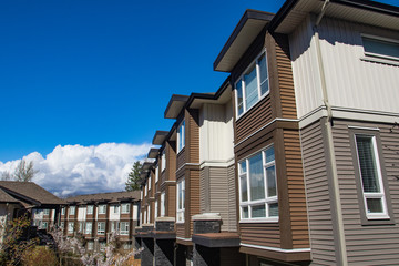 New modern low rise appartament complex on a sunny spring day with blooming sakura trees.