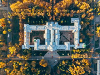 Top view of old building architecture in autumn city landscape with yellow trees and urban traffic