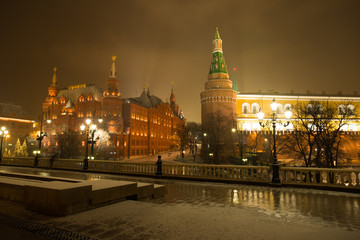Moscow, Russia. On Background Ancient Famous Architectural Buildings Of State Historical Museum And Moscow Kremlin Corner Arsenal Tower On Manege Square With Illumination Lamps In Evening At Winter.