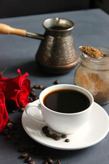 Close-up of a Cup of black instant coffee on the table , a bouquet of red roses