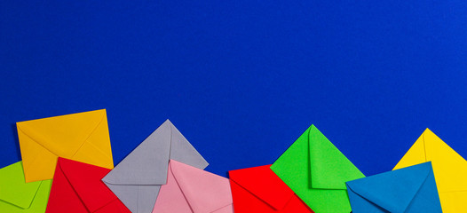 Colorful envelopes on blue background, top view