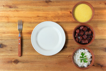 dish and fork next to feijoada, traditional brazilian culinary food top view
