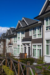 Suburban residential street townhomes. On bright sunny spring day against bright blue sky.