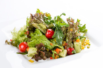 Salad with avocado and vegetables on a white plate