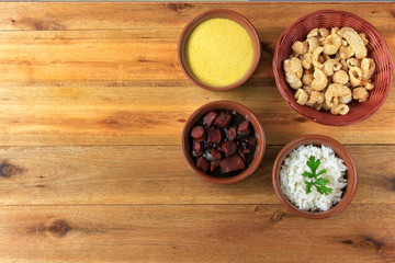 Brazilian feijoada, traditional dish of the Brazilian cuisine, on wooden table