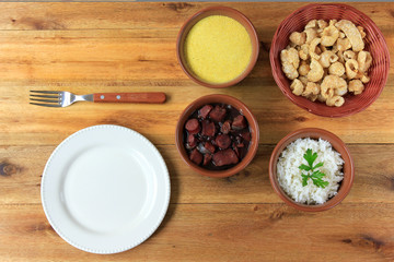 dish and fork next to feijoada, traditional brazilian culinary food top view