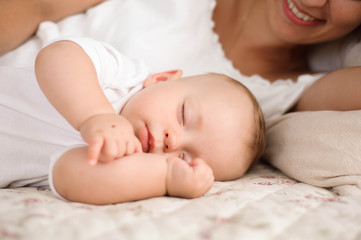 Fototapeta na wymiar Sweet baby boy sleeping in bed with his mother