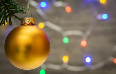 Close up of ornaments on a twig Christmas tree and background with colorful lights