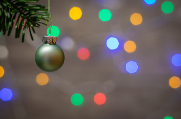 Close up of ornaments on a twig Christmas tree and background with colorful lights