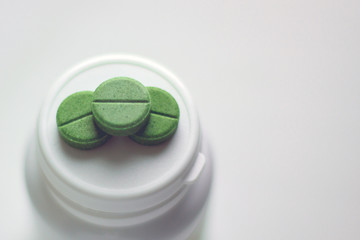 three pills on the lid of a medicine jar. selective focus