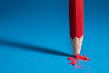 Roter Buntstift zum Malen und blauer Hintergrund