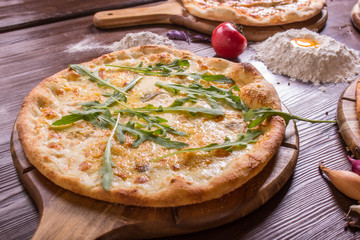 Assorted pizza with seafood and cheese, four cheeses and arugula, pepperoni, meat, margarita on a wooden stand with spices