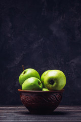 Apples with copy space on the table in a clay bowl