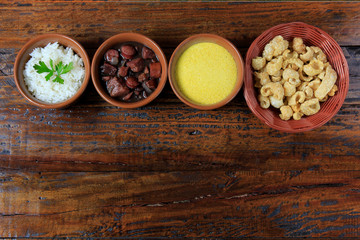 Brazilian feijoada, traditional dish of the Brazilian cuisine, on wooden table