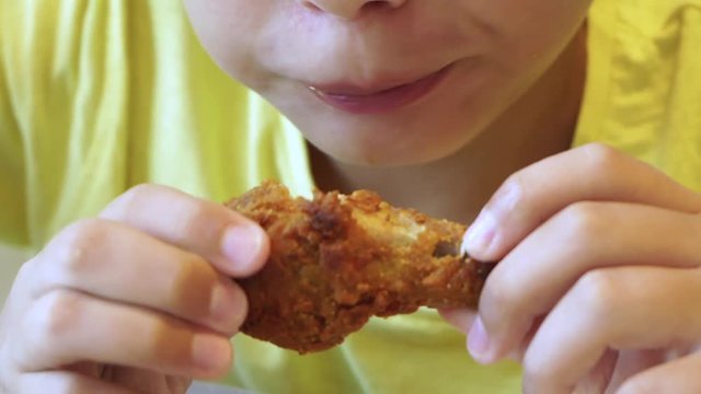 Closeup View Of Hungry Cute Little White Kid Eating Tasty Barbecued Chicken Wings With Great Appetite At Fast Food Restaurant. Real Time Full Hd Video Footage.