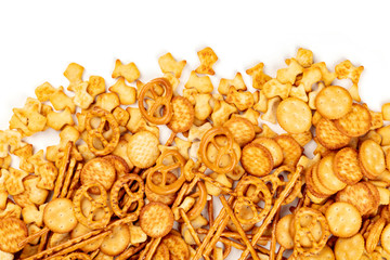A photo of an assortment of salt crackers, sticks, pretzels, and fishes, shot from above on a white background with a place for text