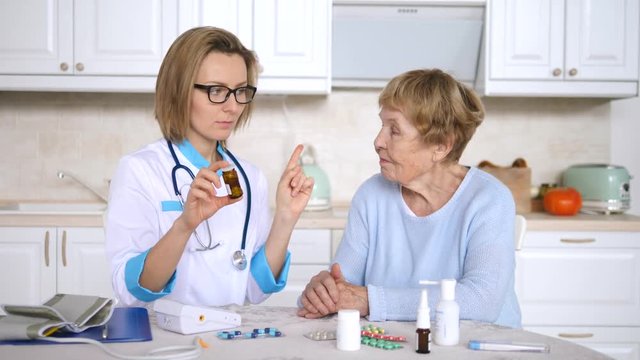 Woman Doctor Prescribes A Drug To Elderly Woman Patient And Informs About Precautions.