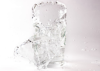 Falling and crashing glass of water. Shards of glass and splashing water