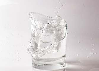 Falling and crashing glass of water. Shards of glass and splashing water