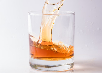 A shattering glass of brandy or brandy. Shards of glass and splashes of drink