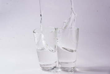 Glasses of water falling and jumping with splashes and drops	