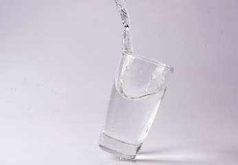 Glasses of water falling and jumping with splashes and drops	