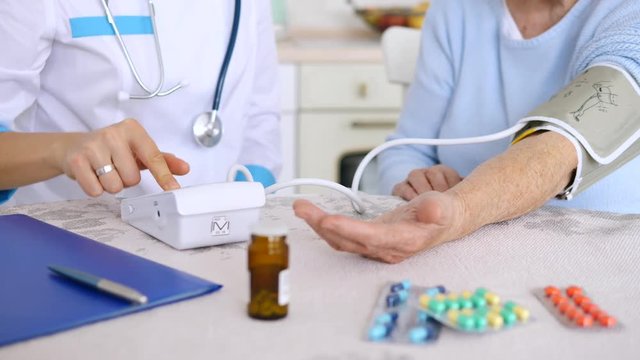 Doctor Checking Old Woman Patient Arterial Blood Pressure. Health Care.