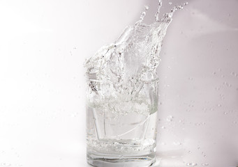 Naklejka na ściany i meble Falling and crashing glass of water. Shards of glass and splashing water