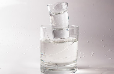 Falling and crashing glass of water. Shards of glass and splashing water