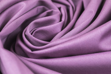 The monophonic fabric of lilac color showing a beautiful drapery a spiral.