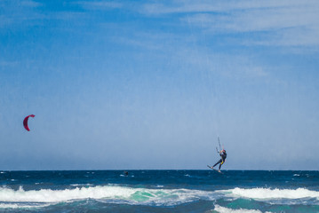 Kite surf jump at the beach with blue sky