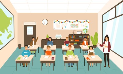 Pupils sitting at desks in modern classroom, young female teacher teaching them. Elementary school boys and girls studying on lesson in class. Colorful vector illustration in flat cartoon style. © Good Studio
