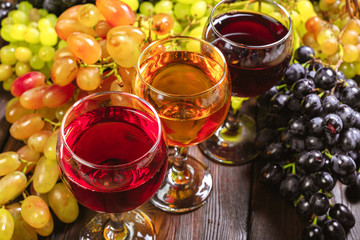 wine with branches of white grapes. On a wooden table.