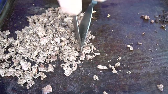 Chopping A Cheese Steak On A Griddle