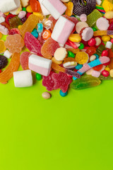 Colorful candies on green background