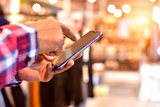 Close-up Hands Using Smartphone At Shopping Street, Hipster Man Searching Or Social Networks Concept.