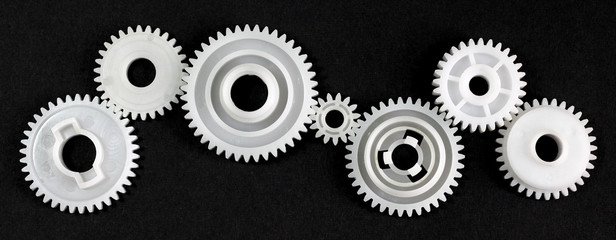 Several gears that are in connection with each other on black background