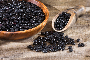 Fototapeta na wymiar Raw black beans - Wooden bowl
