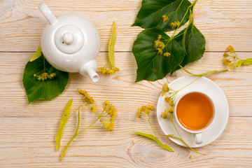 linden herbal tea with raw plant on wooden table