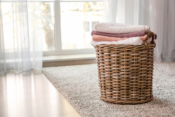 Wicker basket with folded clean towels on floor