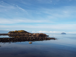 small island in the sea blue sky and rocky shore